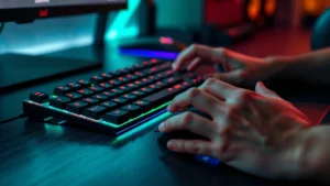Close-up of gaming keyboard and mouse on desk with RGB lighting, showing player's hands positioned ready for intense rhythm game session, competitive gaming setup atmosphere